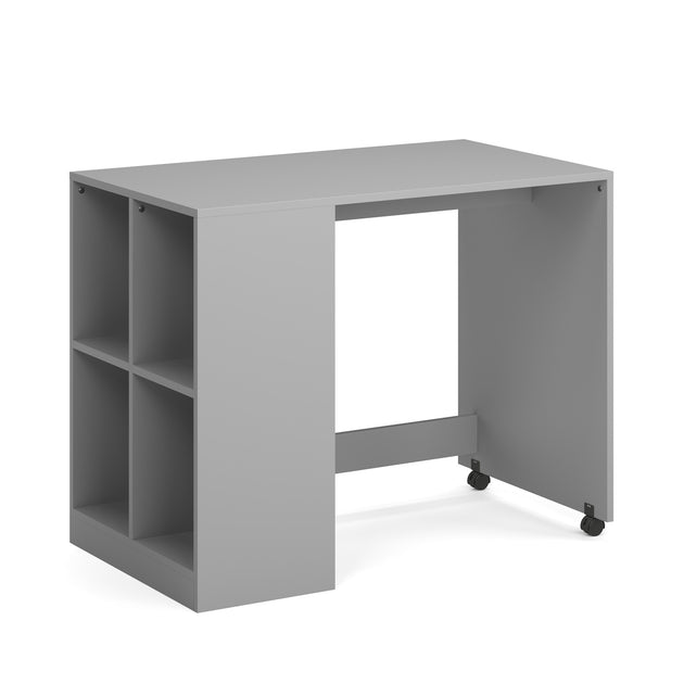 A grey desk with a 4 cube bookcase built-in to the side.